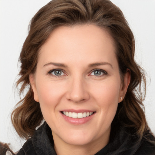 Joyful white young-adult female with long  brown hair and grey eyes