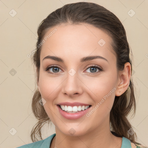 Joyful white young-adult female with medium  brown hair and green eyes