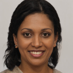 Joyful black young-adult female with medium  brown hair and brown eyes