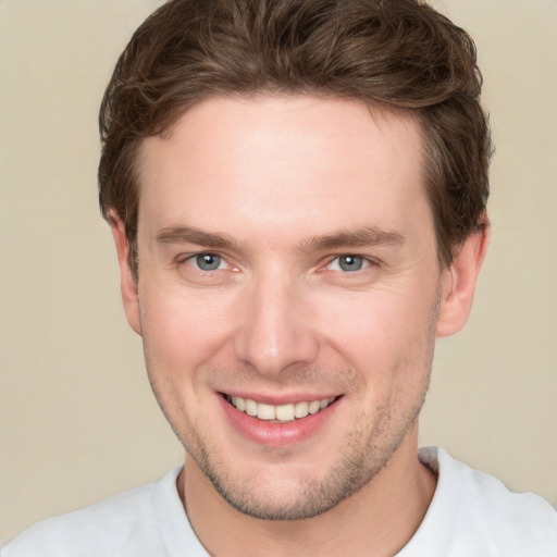 Joyful white young-adult male with short  brown hair and grey eyes