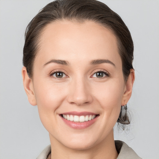 Joyful white young-adult female with medium  brown hair and grey eyes