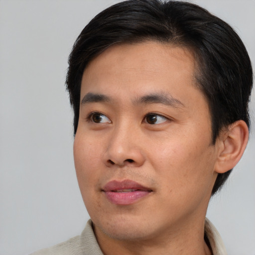 Joyful asian young-adult male with short  black hair and brown eyes