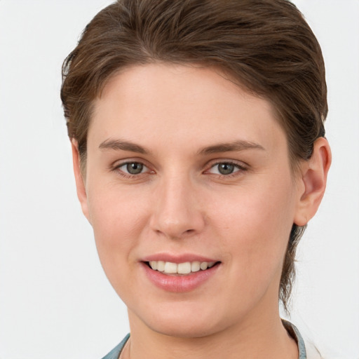 Joyful white young-adult female with short  brown hair and grey eyes