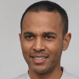 Joyful latino young-adult male with short  black hair and brown eyes