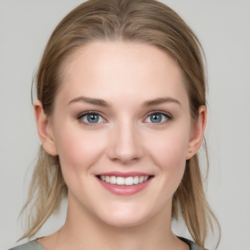 Joyful white young-adult female with medium  brown hair and grey eyes