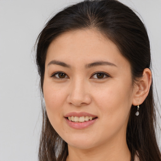 Joyful white young-adult female with long  brown hair and brown eyes