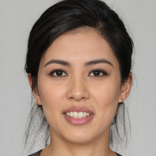 Joyful latino young-adult female with medium  brown hair and brown eyes