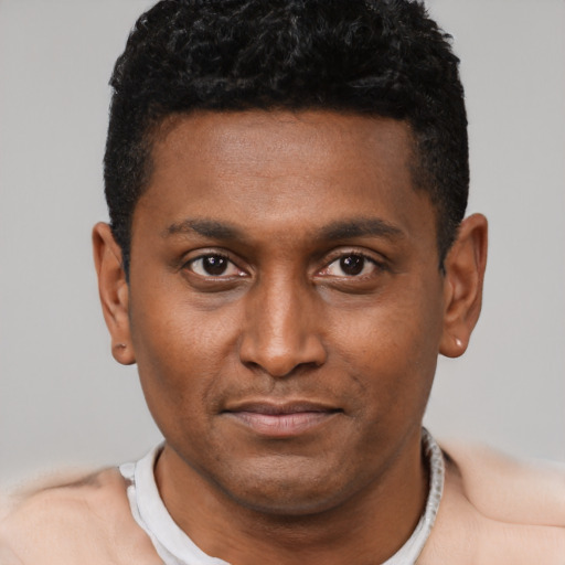 Joyful black young-adult male with short  black hair and brown eyes