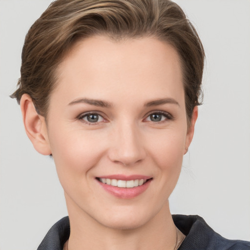 Joyful white young-adult female with short  brown hair and grey eyes