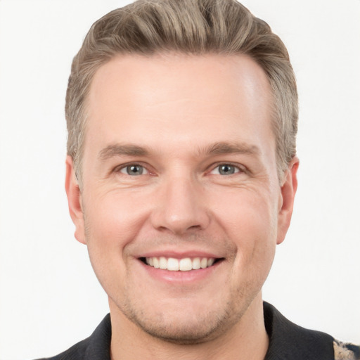 Joyful white young-adult male with short  brown hair and grey eyes