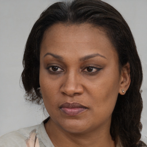 Joyful black adult female with long  brown hair and brown eyes