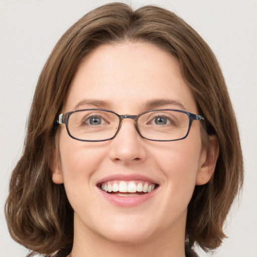 Joyful white young-adult female with medium  brown hair and green eyes