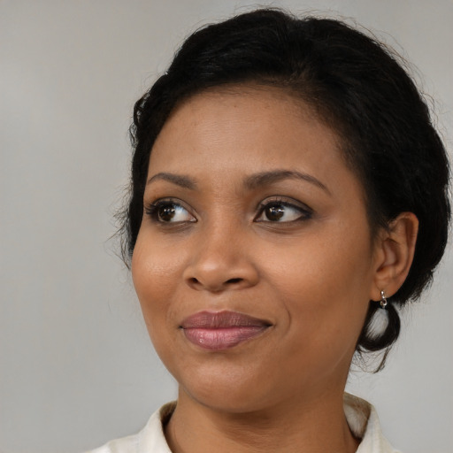 Joyful black young-adult female with medium  black hair and brown eyes