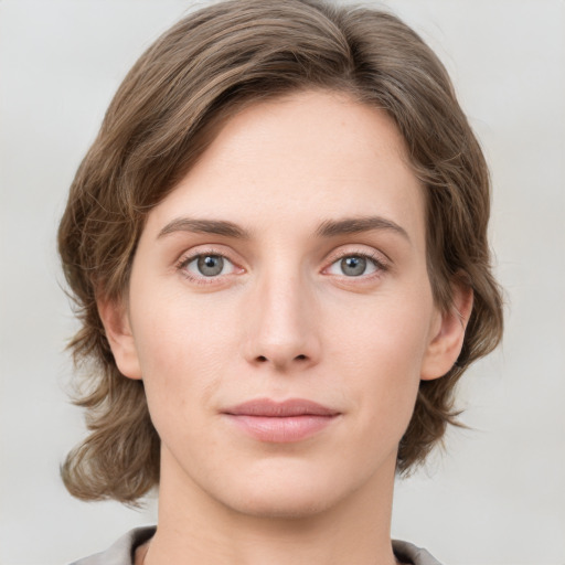 Joyful white young-adult female with medium  brown hair and green eyes