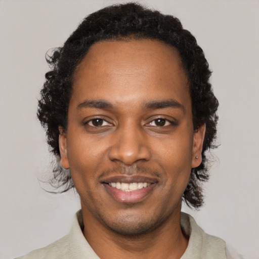 Joyful black young-adult male with short  black hair and brown eyes
