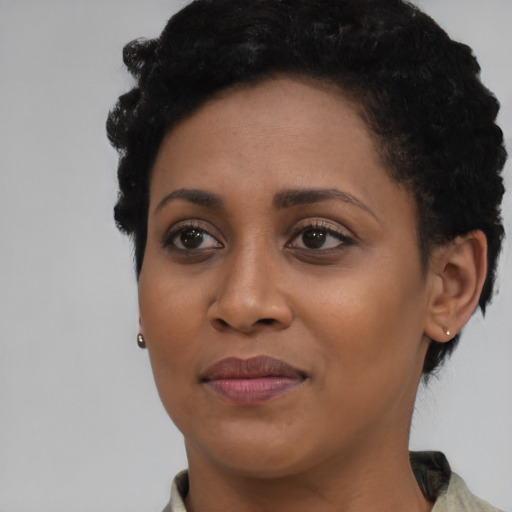 Joyful black young-adult female with short  brown hair and brown eyes