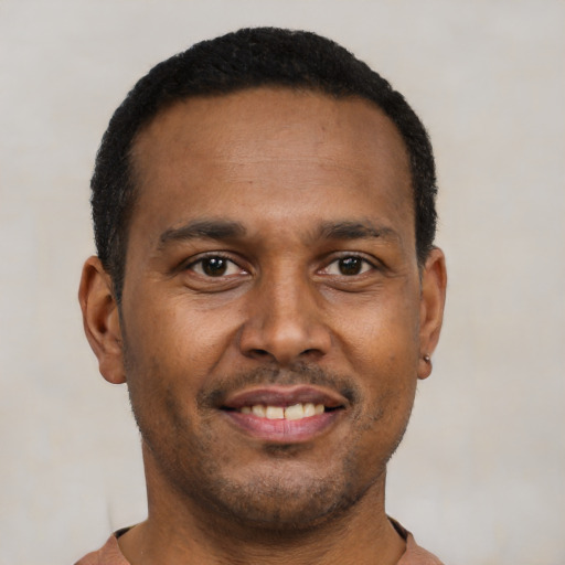 Joyful latino young-adult male with short  brown hair and brown eyes