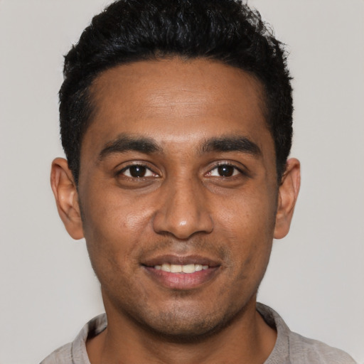 Joyful black young-adult male with short  black hair and brown eyes
