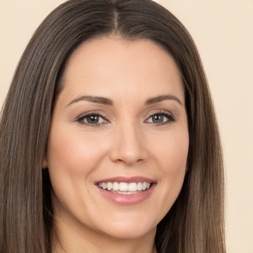 Joyful white young-adult female with long  brown hair and brown eyes