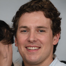 Joyful white adult male with medium  brown hair and brown eyes