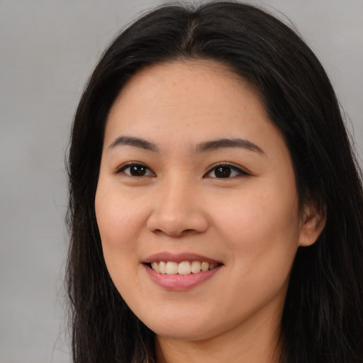 Joyful asian young-adult female with long  brown hair and brown eyes