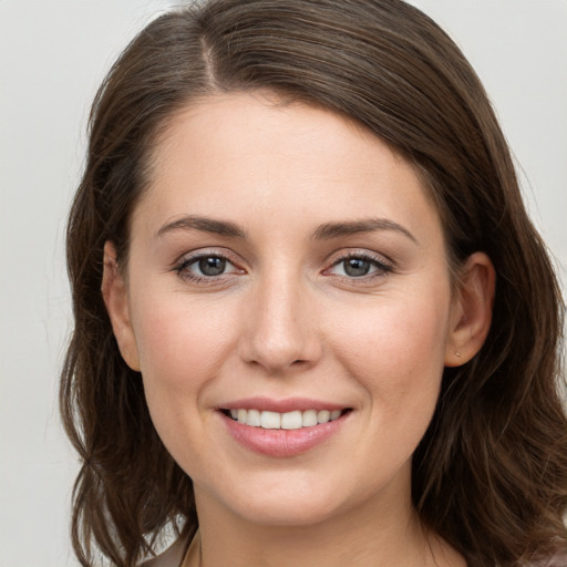 Joyful white young-adult female with long  brown hair and grey eyes