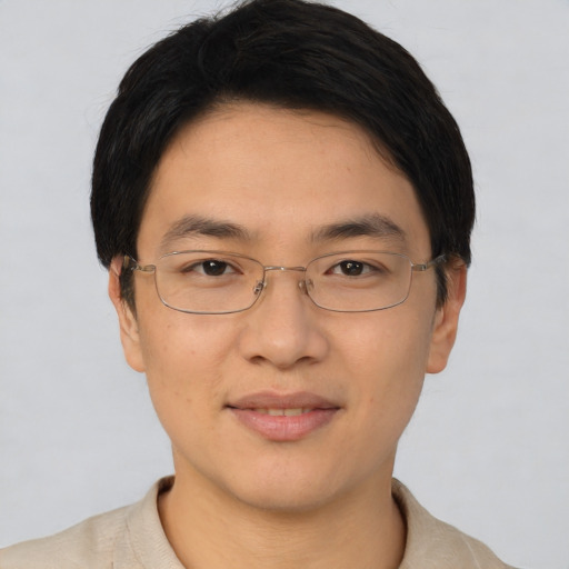 Joyful asian young-adult male with short  brown hair and brown eyes