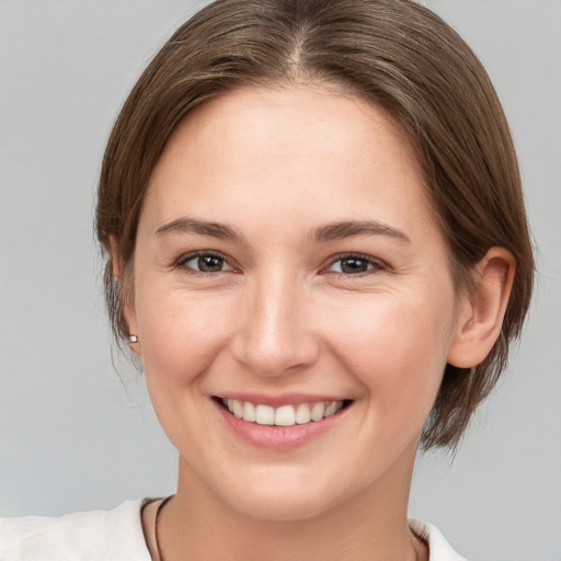 Joyful white young-adult female with medium  brown hair and brown eyes