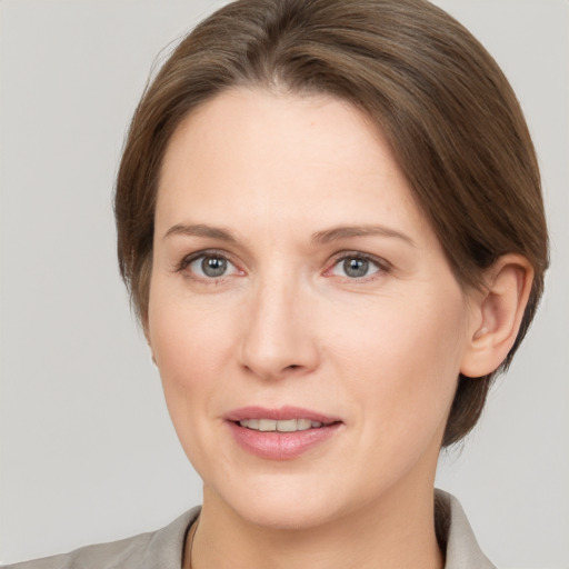 Joyful white young-adult female with medium  brown hair and grey eyes