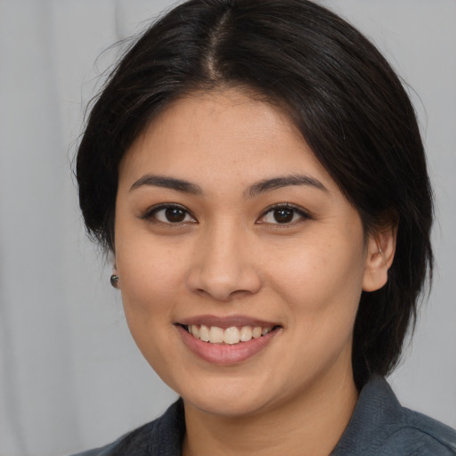 Joyful asian young-adult female with medium  brown hair and brown eyes