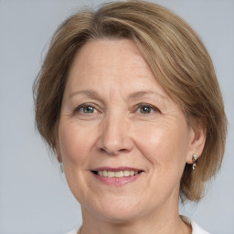 Joyful white adult female with medium  brown hair and grey eyes