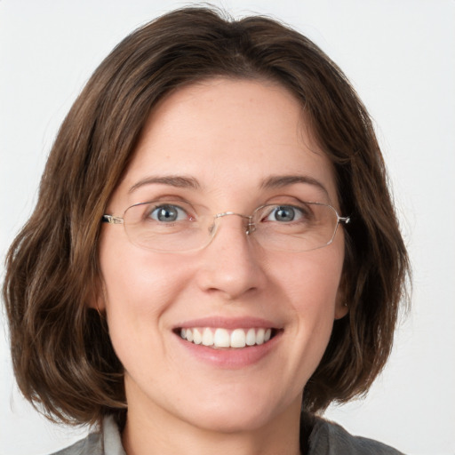 Joyful white young-adult female with medium  brown hair and green eyes