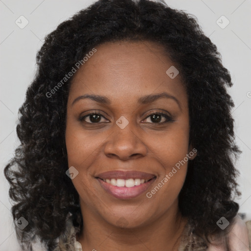 Joyful black adult female with long  brown hair and brown eyes