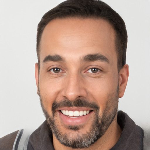 Joyful white young-adult male with short  black hair and brown eyes