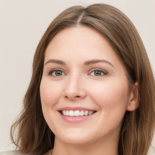 Joyful white young-adult female with long  brown hair and grey eyes