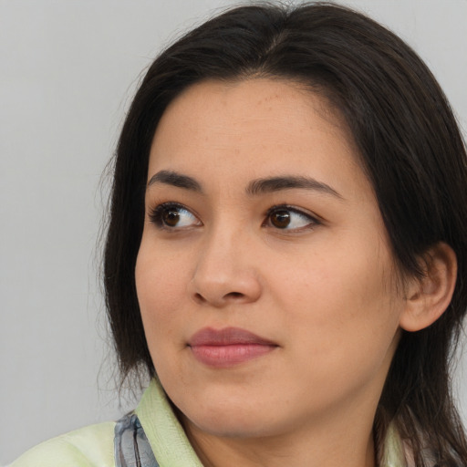 Joyful asian young-adult female with long  brown hair and brown eyes