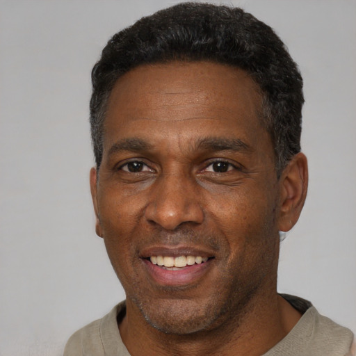 Joyful black adult male with short  black hair and brown eyes