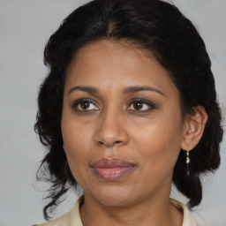 Joyful black adult female with medium  brown hair and brown eyes