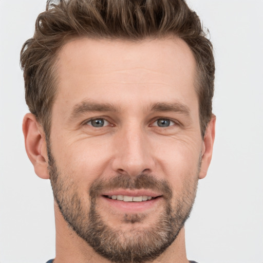 Joyful white young-adult male with short  brown hair and grey eyes