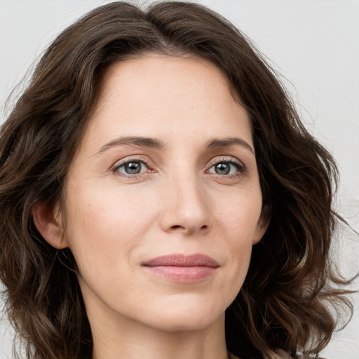 Joyful white young-adult female with long  brown hair and green eyes