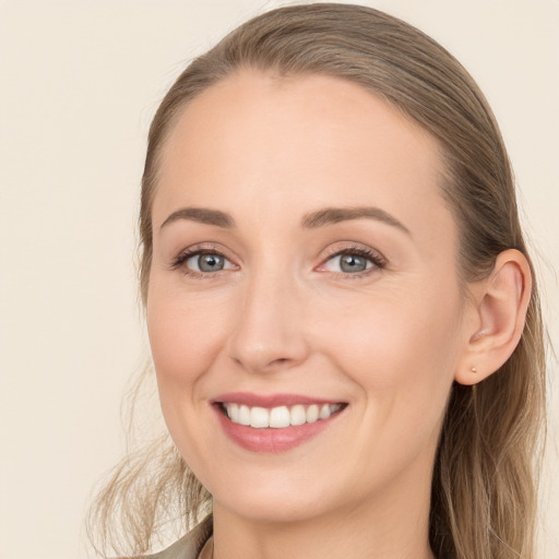 Joyful white young-adult female with long  brown hair and blue eyes