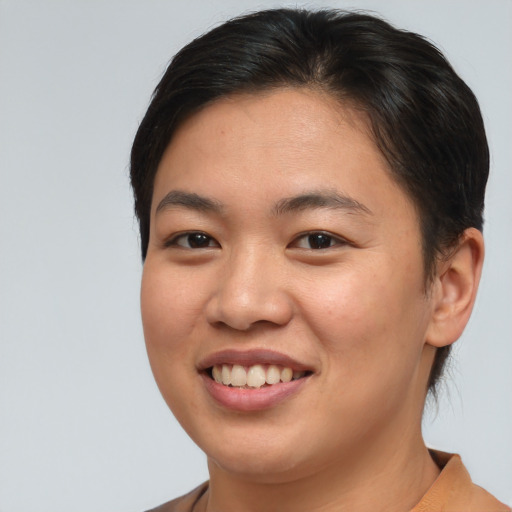 Joyful asian young-adult female with short  brown hair and brown eyes