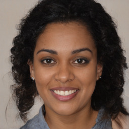 Joyful black young-adult female with long  brown hair and brown eyes