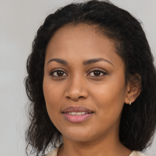 Joyful black young-adult female with long  brown hair and brown eyes
