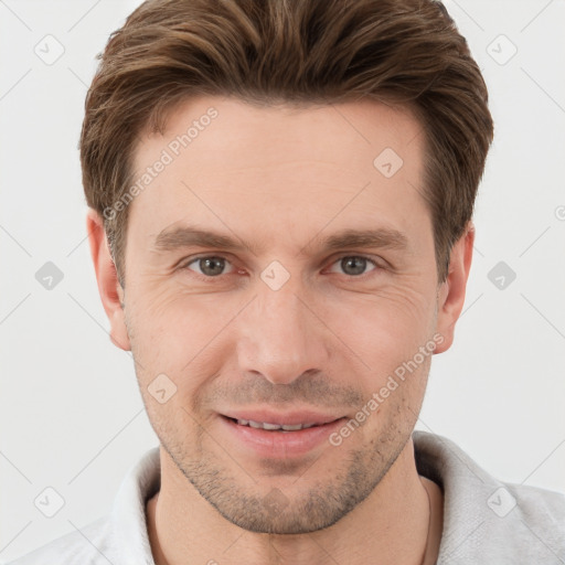 Joyful white young-adult male with short  brown hair and grey eyes