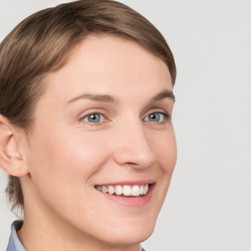 Joyful white young-adult female with short  brown hair and grey eyes