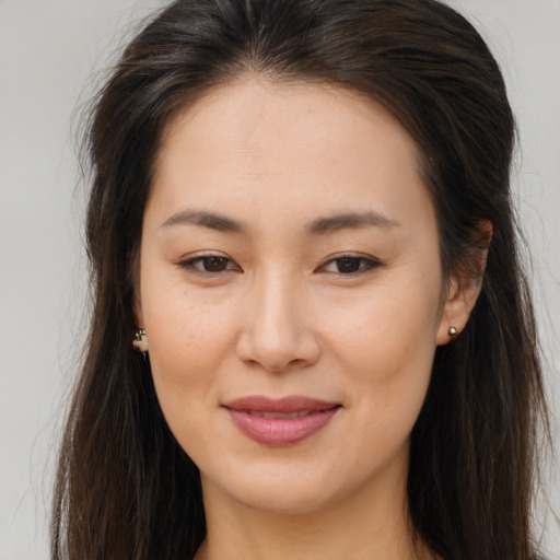 Joyful asian young-adult female with long  brown hair and brown eyes