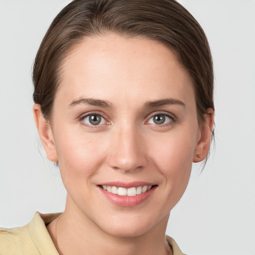 Joyful white young-adult female with medium  brown hair and grey eyes