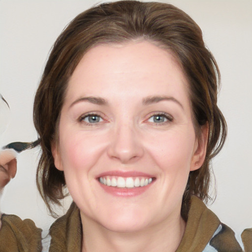 Joyful white young-adult female with medium  brown hair and blue eyes