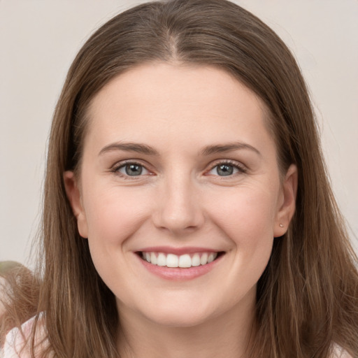 Joyful white young-adult female with long  brown hair and grey eyes